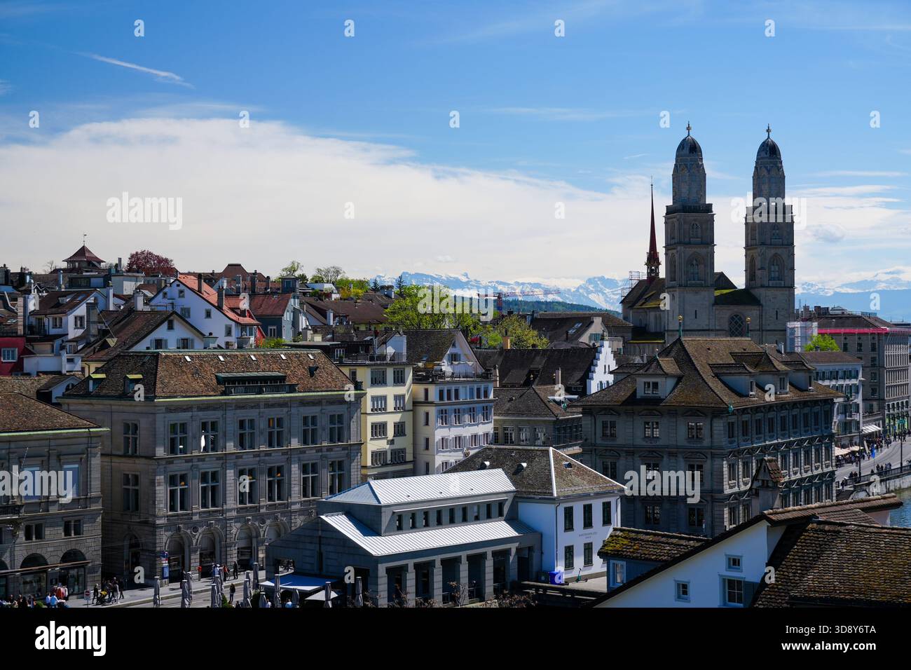 Zurich Altstadt skyline featuring Grossmünster church twin towers and  snow-capped Swiss Alps under a blue spring sky Stock Photo - Alamy, image size:1300x956