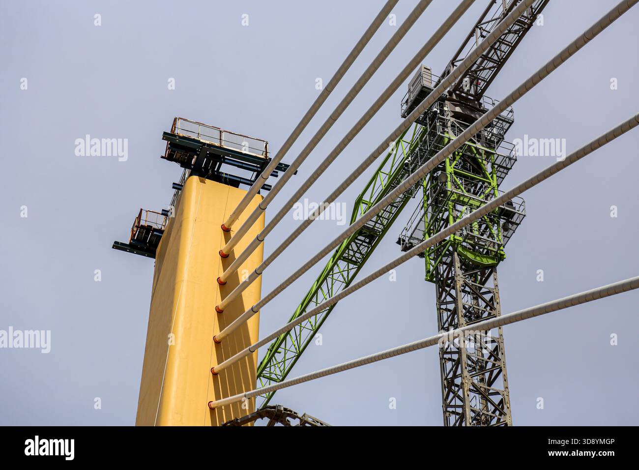 Cable-Stayed Bridge Construction with Tower Crane Under Blue Sky Stock Photo