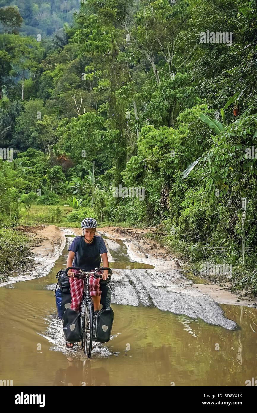 Female Cyclist Cycling On Trans sumatran Highway In Sumatra Indonesia 