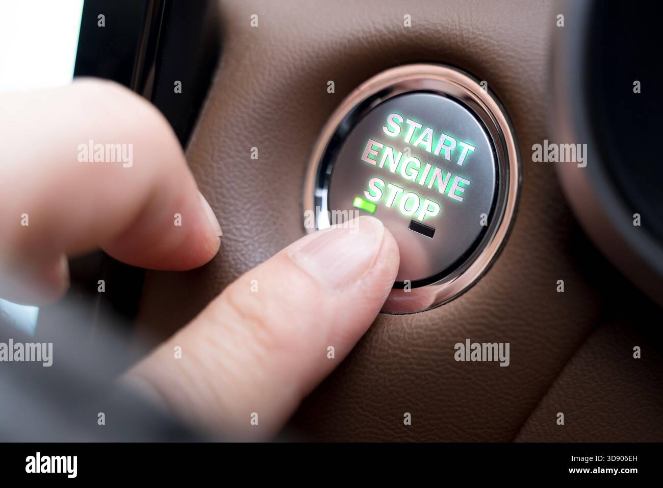 A close-up of a finger pressing a Start Engine Stop button in a modern car interior, representing technology, control, safety, and convenience. Ideal Stock Photo