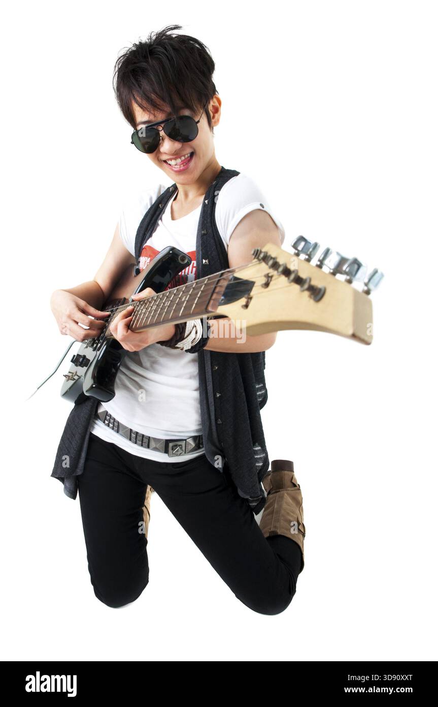 Punk Rockstar holding a guitar kneeling isolated in white Stock Photo ...