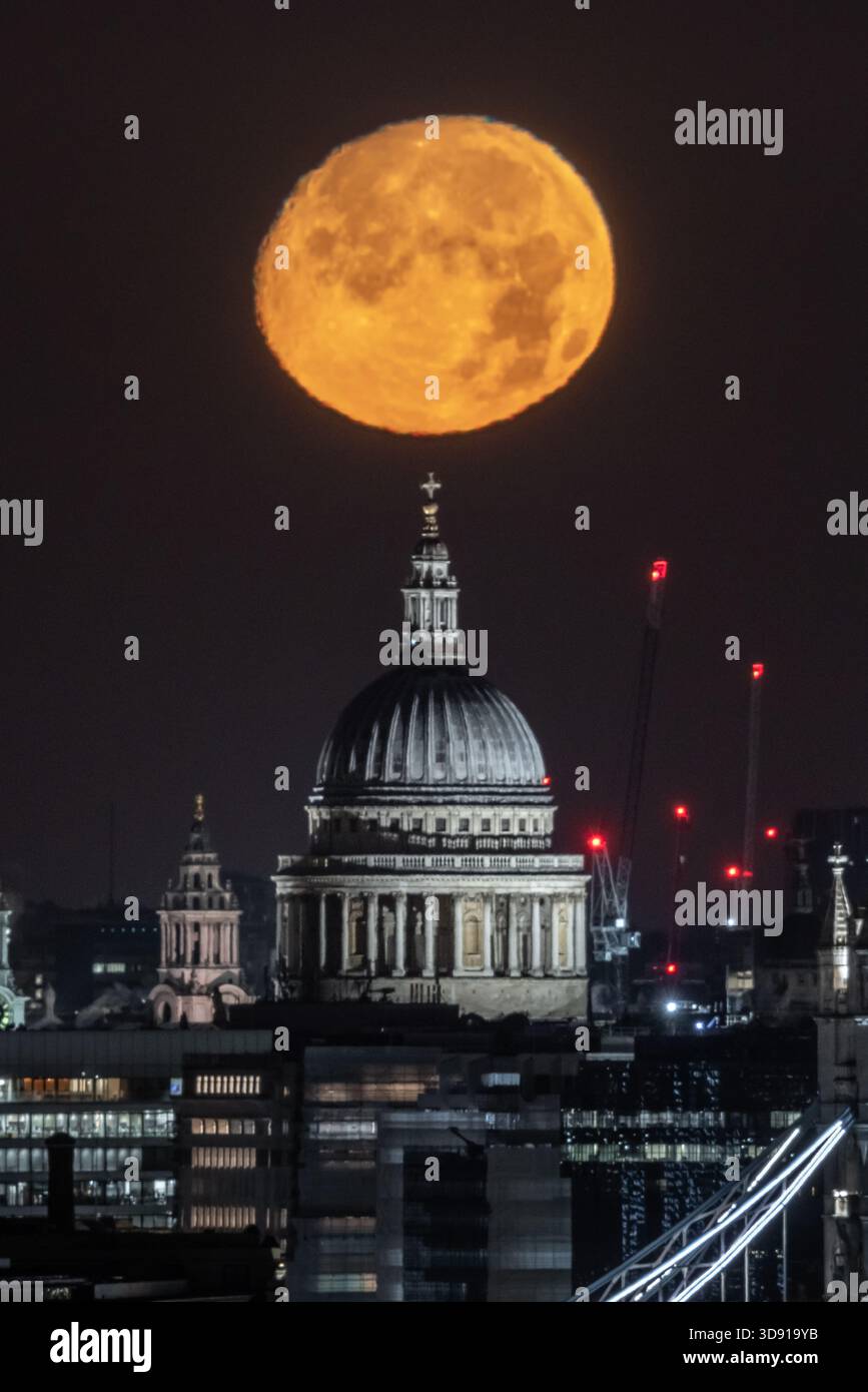 London, UK. 3rd December 2025. UK Weather:  ‘Cold Supermoon’ sets over the city. A nearly full (98.2%) Cold Moon, also the third consecutive (and final) supermoon of the year, sets in the early hours of Wednesday morning over St Paul's Cathedral city landmark. At its perigree - the point at which the moon is closest to Earth - the moon can appear 14% bigger and 30% brighter than the faintest moon of the year, according to NASA. Credit: Guy Corbishley/Alamy Live News Stock Photo