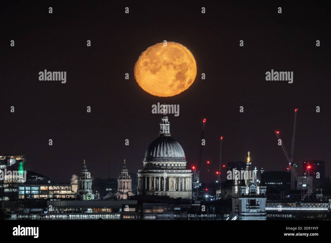 London, UK. 3rd December 2025. UK Weather:  ‘Cold Supermoon’ sets over the city. A nearly full (98.2%) Cold Moon, also the third consecutive (and final) supermoon of the year, sets in the early hours of Wednesday morning over St Paul's Cathedral city landmark. At its perigree - the point at which the moon is closest to Earth - the moon can appear 14% bigger and 30% brighter than the faintest moon of the year, according to NASA. Credit: Guy Corbishley/Alamy Live News Stock Photo