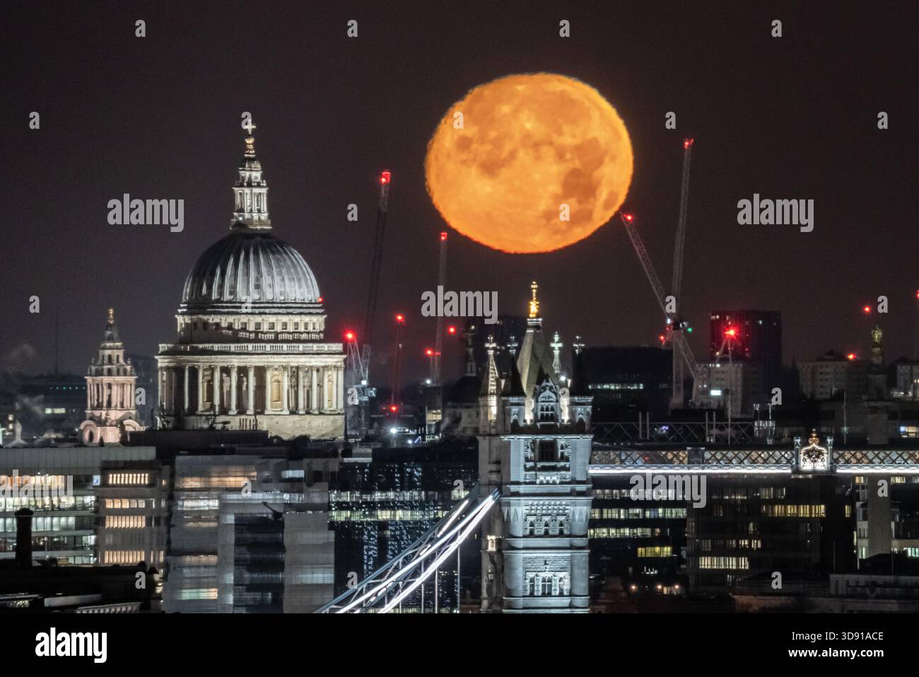 London, UK. 3rd December 2025. UK Weather:  ‘Cold Supermoon’ sets over the city. A nearly full (98.2%) Cold Moon, also the third consecutive (and final) supermoon of the year, sets in the early hours of Wednesday morning over St Paul's Cathedral and Tower Bridge city landmarks. At its perigree - the point at which the moon is closest to Earth - the moon can appear 14% bigger and 30% brighter than the faintest moon of the year, according to NASA. Credit: Guy Corbishley/Alamy Live News Stock Photo