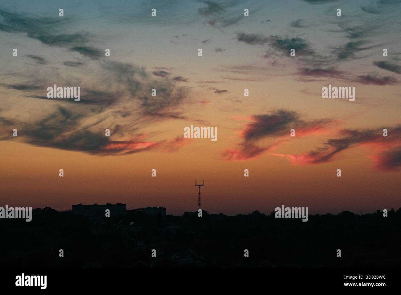 Peach gradient sunset, soft clouds, large metal structure Stock Photo