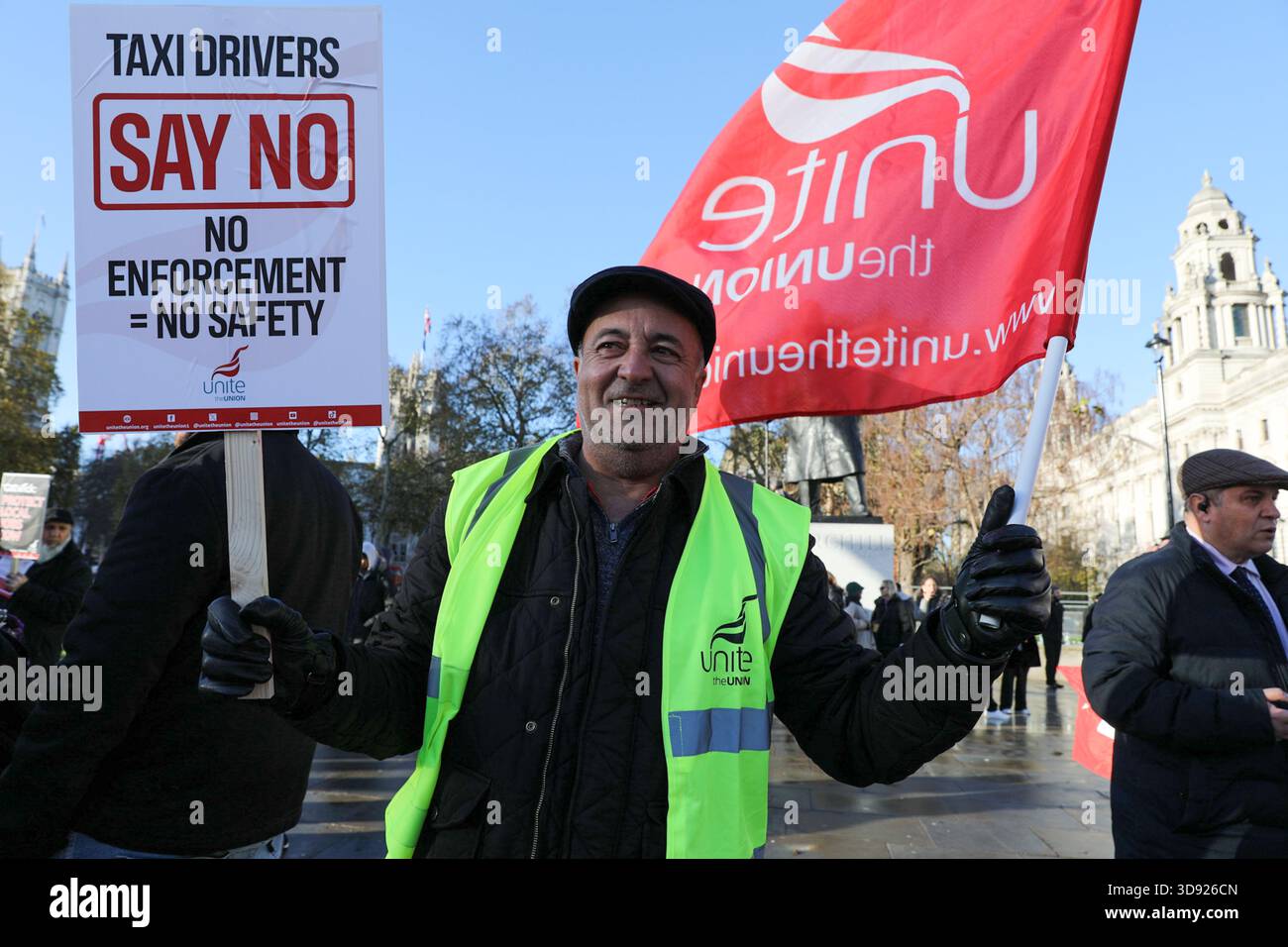 London, UK, 3rd November 2025. A Unite Union member holds a placard and flag during a demonstration. Taxi and private hire drivers protested in Westminster, calling for action on the Casey report's call to end out-of-area licensing. The demonstration, organised by the Unite union, brought together drivers from across the UK who are concerned about regulations, safety, and driver incomes. The key issue is licence shopping—current laws allow drivers to get licensed by any local authority, no matter where they intend to work. Credit:James Willoughby/ALAMY Live News Stock Photo