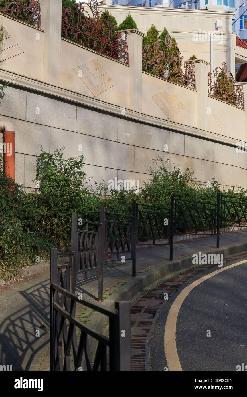 Close-up of elegant wrought iron railing atop beige stone wall with ...