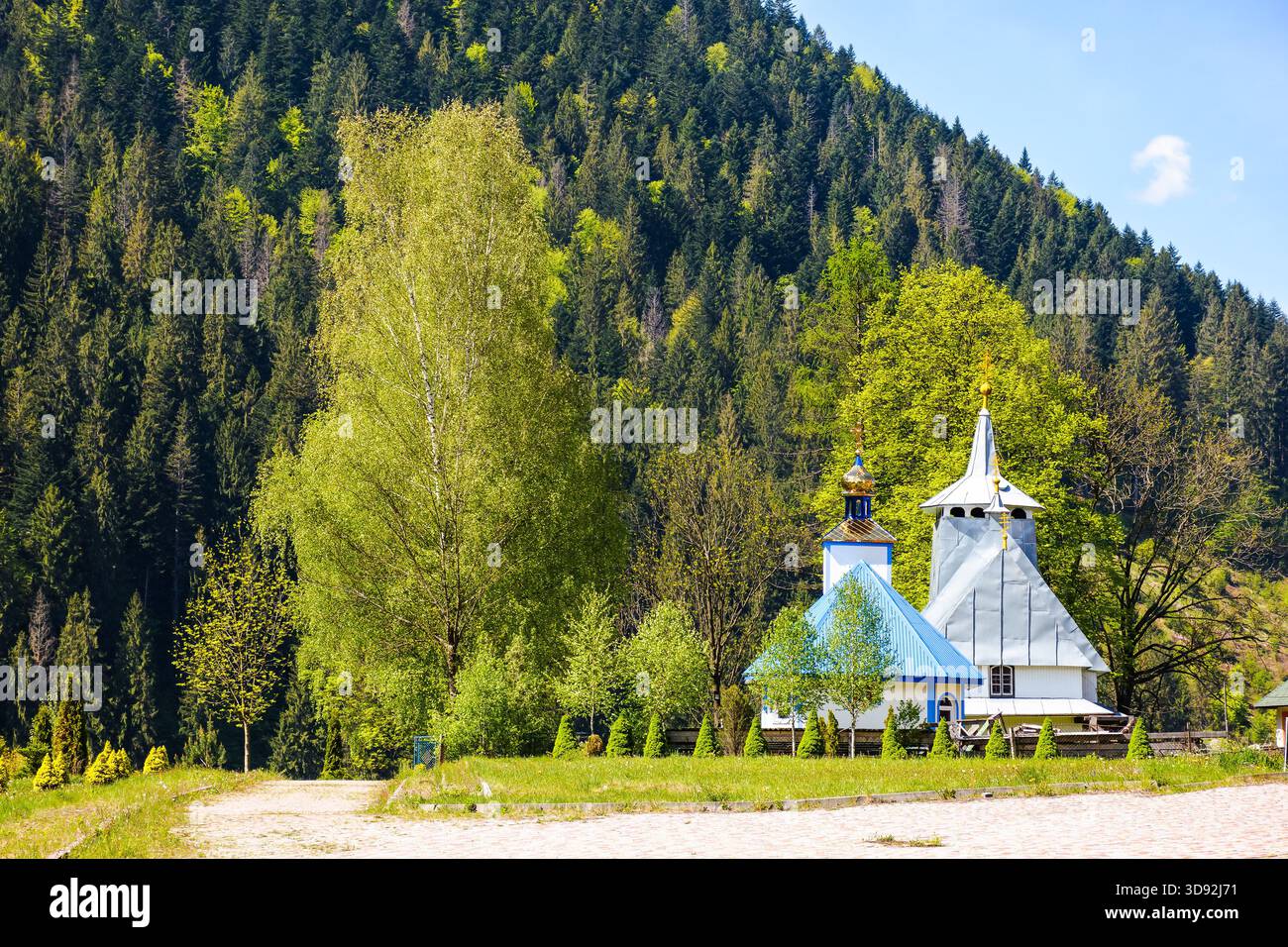 soimy, transcarpathia, ukraine - may 12 2019: orthodox wooden church of saint basil the great. old building with steeple on the hill under blue sky. m Stock Photo
