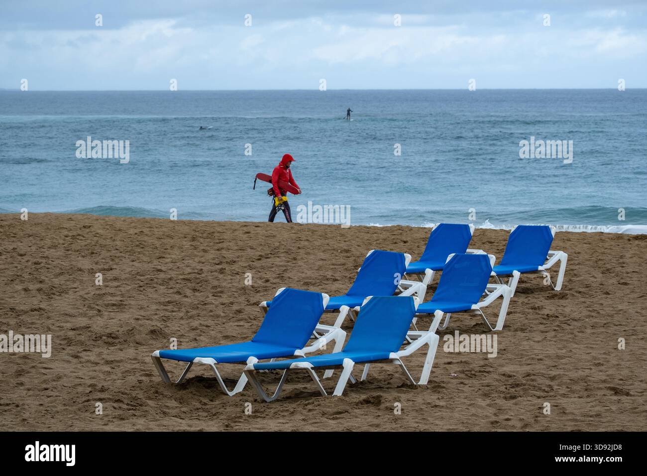 Las Palmas, Gran Canaria, Canary Islands, Spain. 3rd December, 2025. Heavy rain greets British cruise ship passengers as they walk along an empty city beach in Las Palmas on Gran Canaria. PICTURED: a lifeguard patrols an empty beach in the rain. Credit: Alan Dawson/Alamy Live News Stock Photo