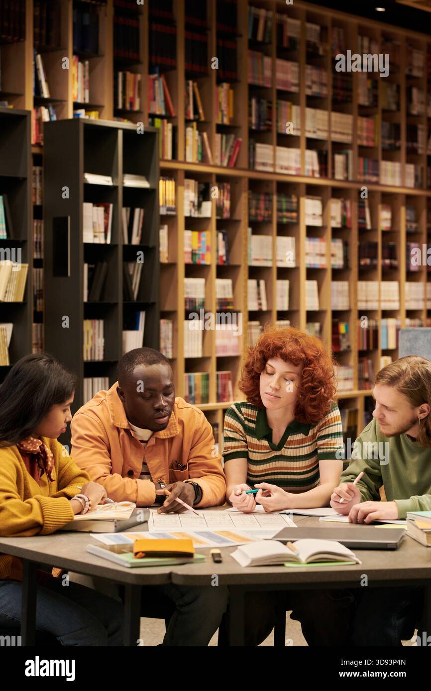 Multiethnic Young People Engaging in Collaborative Study Session in Library Stock Photo