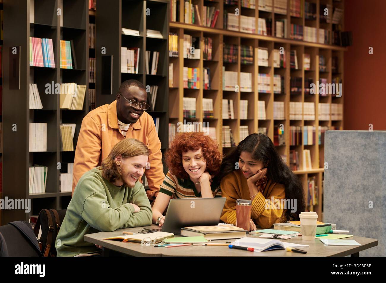 Diverse Group of Young People Collaborating on Project in Library ...