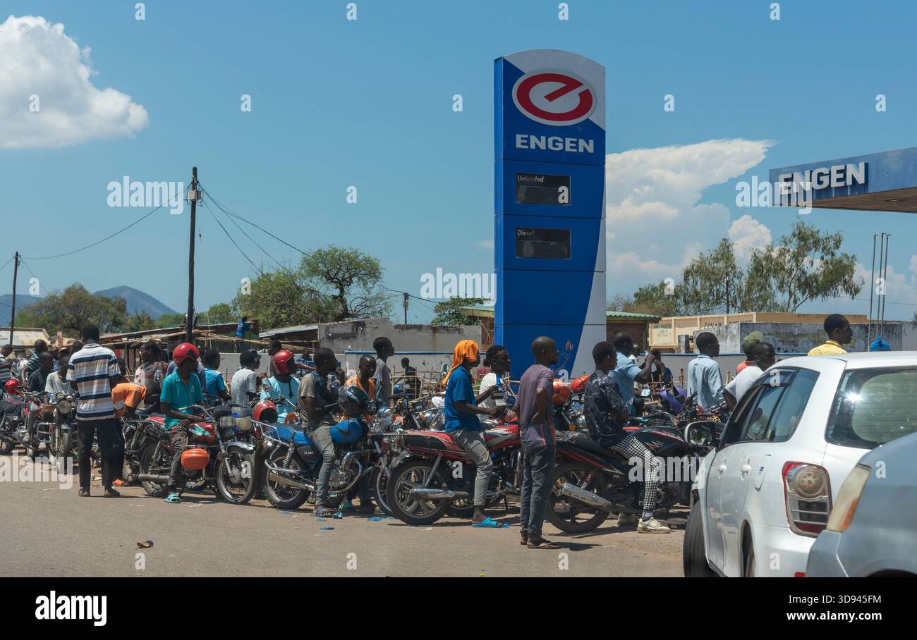 Nakumumba Malawi southern Africa. 16.11.2025.  Motorcyclists sitting on their bikes wait inline for petrol during a shortage of fuel in Malawi Africa. - Stock Image