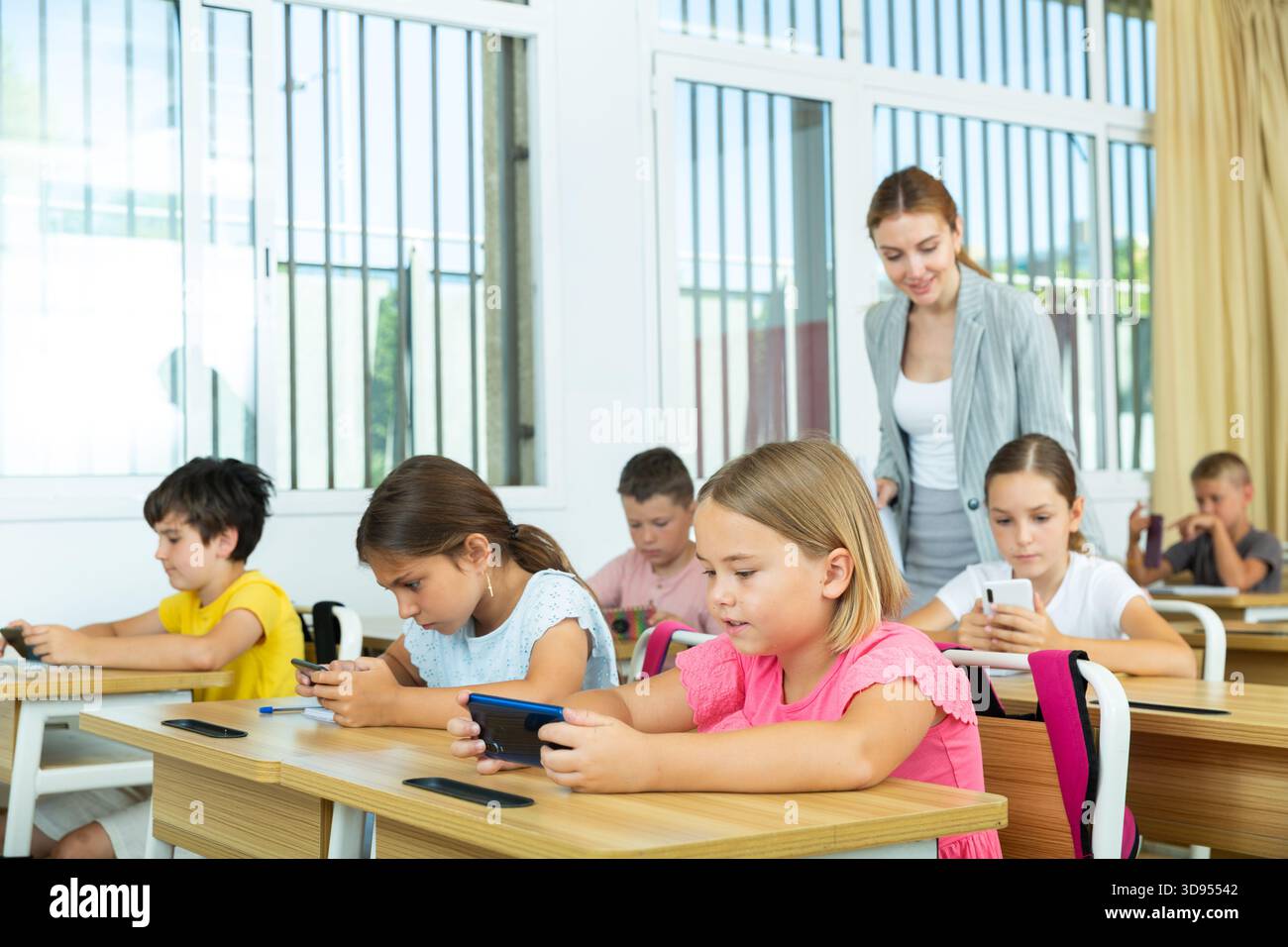 Pupils using mobile phones during lesson in school Stock Photo