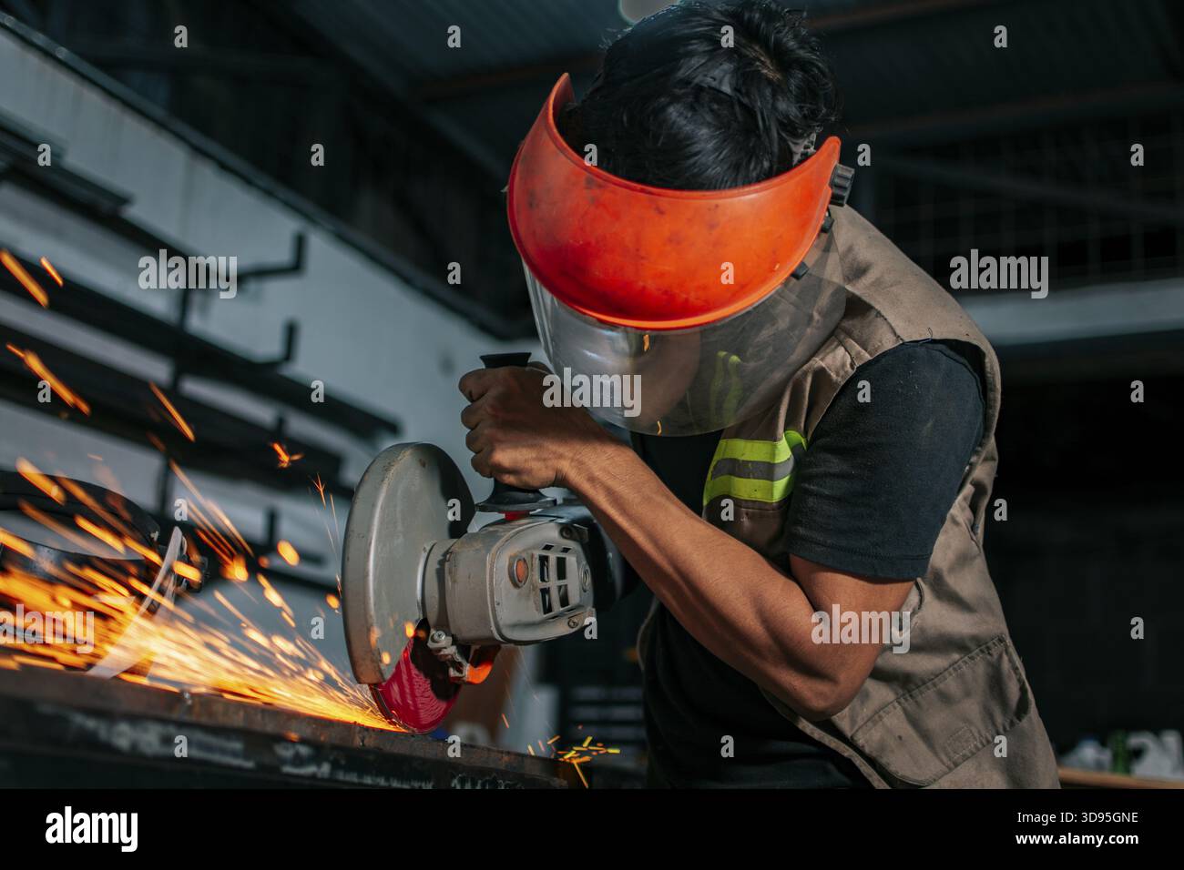 Man using a grinder in a workshop. Metalworking professional using an angle grinder in the workshop Stock Photo