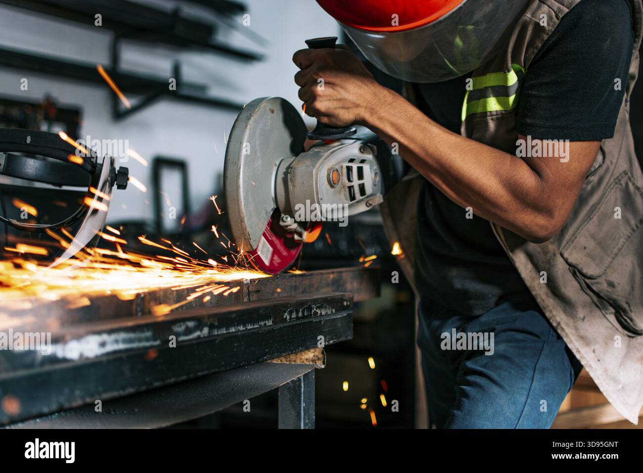 Metalworking professional using an angle grinder in the workshop. Man using a grinder in a workshop Stock Photo