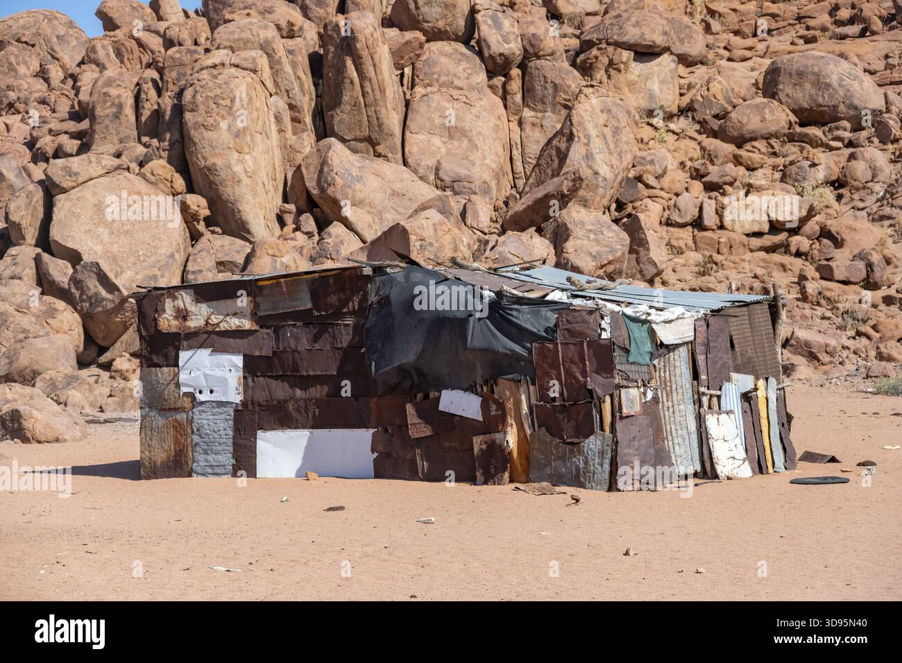 Poor Organization Rocks Simple poor huts made of corrugated iron and wood, desert landscape ...