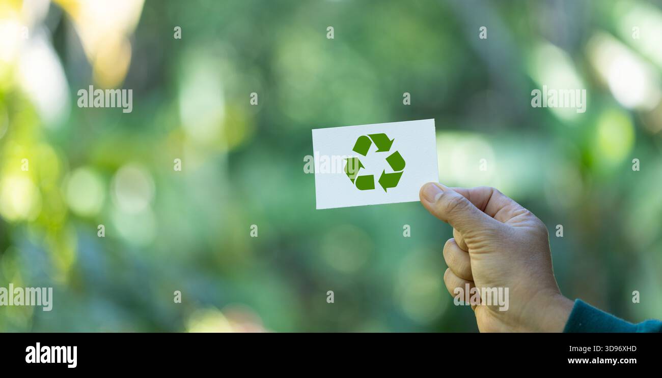 eco living, environment and sustainability concept. Hand holding recycle symbol on green bokeh background. eco and save the earth concept. Save the pl Stock Photo
