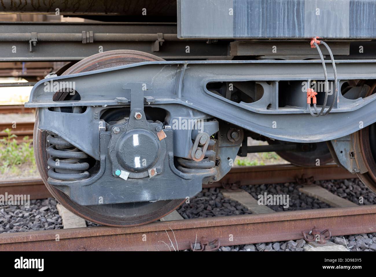 Metal freight wagon bogie with heavy steel springs and worn wheel ...