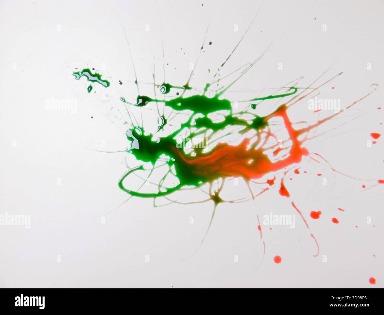 Paint Aftermath With Green And Red Spread Across White Surface, Blended Edges And Scattered Droplets Create Stock Photo