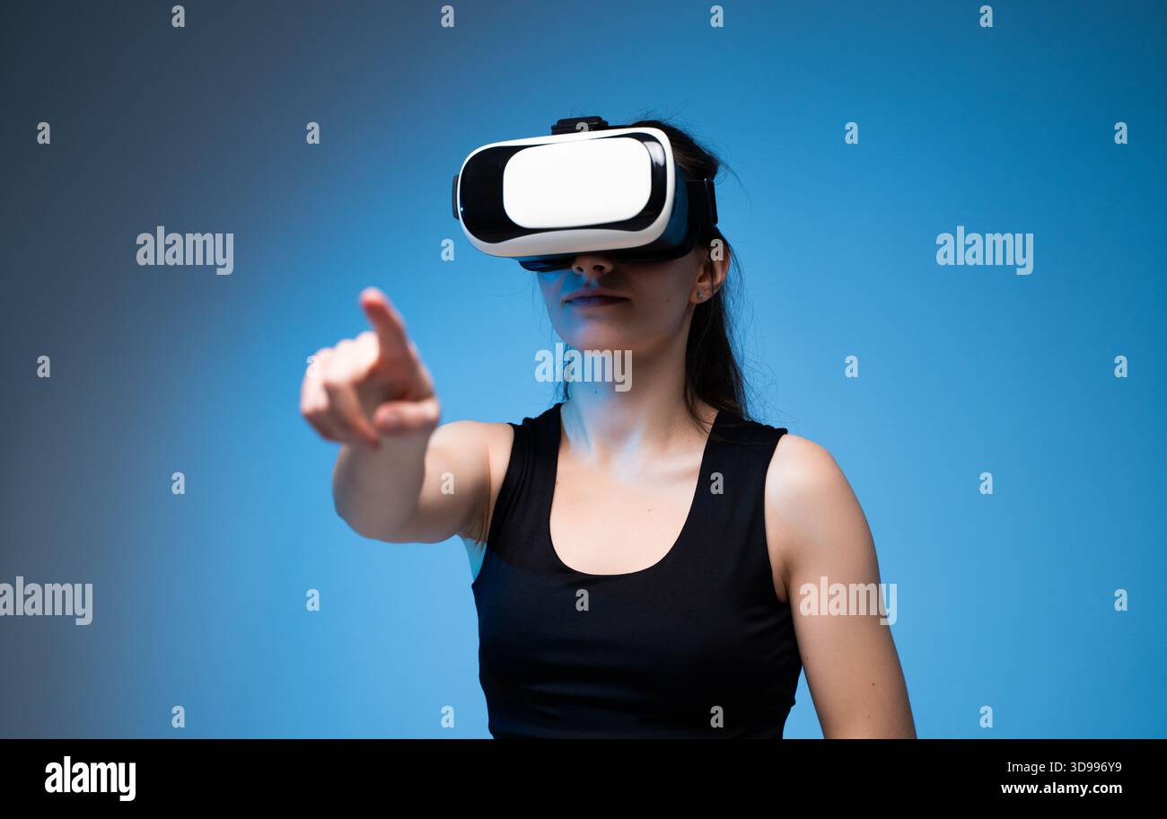 Woman using virtual reality headset and interacting with digital interface in immersive VR environment Stock Photo