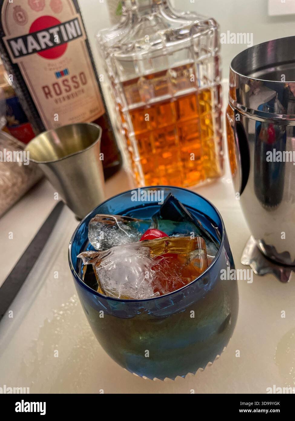 Still life of a classic Manhattan cocktail on the rocks in a crystal glass in front of a crystal decanter, 2025, United States - Smartphone Captured Stock Image