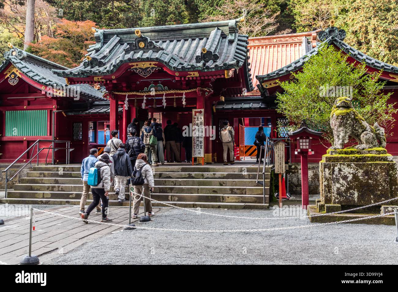 Visitors enter the haiden (prayer hall) of Hakone-jinja Shrine in Hakone. The shrine, founded in 757 during the reign of Emperor Kōken, is regarded as one of the most important shrines in the Kantō region and is dedicated to Yamasachi-hiko, the god of the Kamikaze mountain. Hakone, Kanagawa Prefecture, Japan Stock Photo