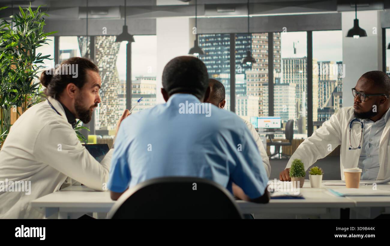 Health specialists and medics collaborating in conference room. Healthcare staff brainstorming treatment ideas and wellness through teamwork and communication in boardroom. Stock Photo
