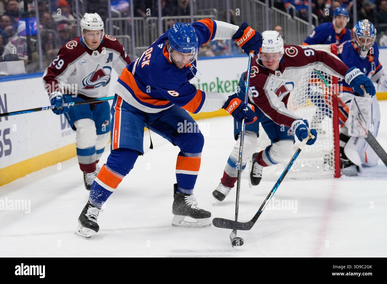 New York Islanders' Ryan Pulock (6), center, maneuvers the puck brings ...