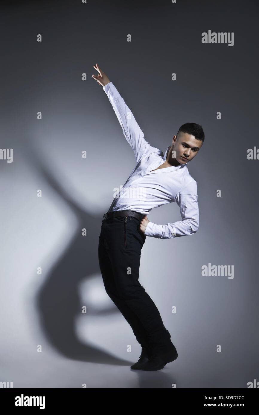 Modern style dancer posing on grey studio background Stock Photo