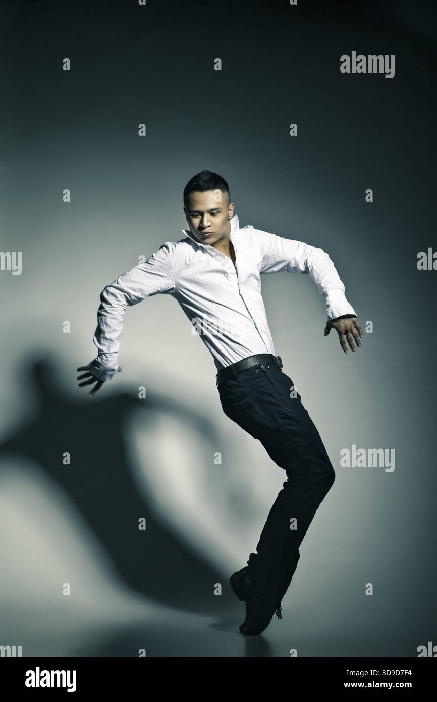 Modern style dancer posing on grey studio background Stock Photo