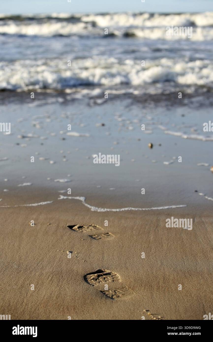 Pair prints of female boots on sand Stock Photo