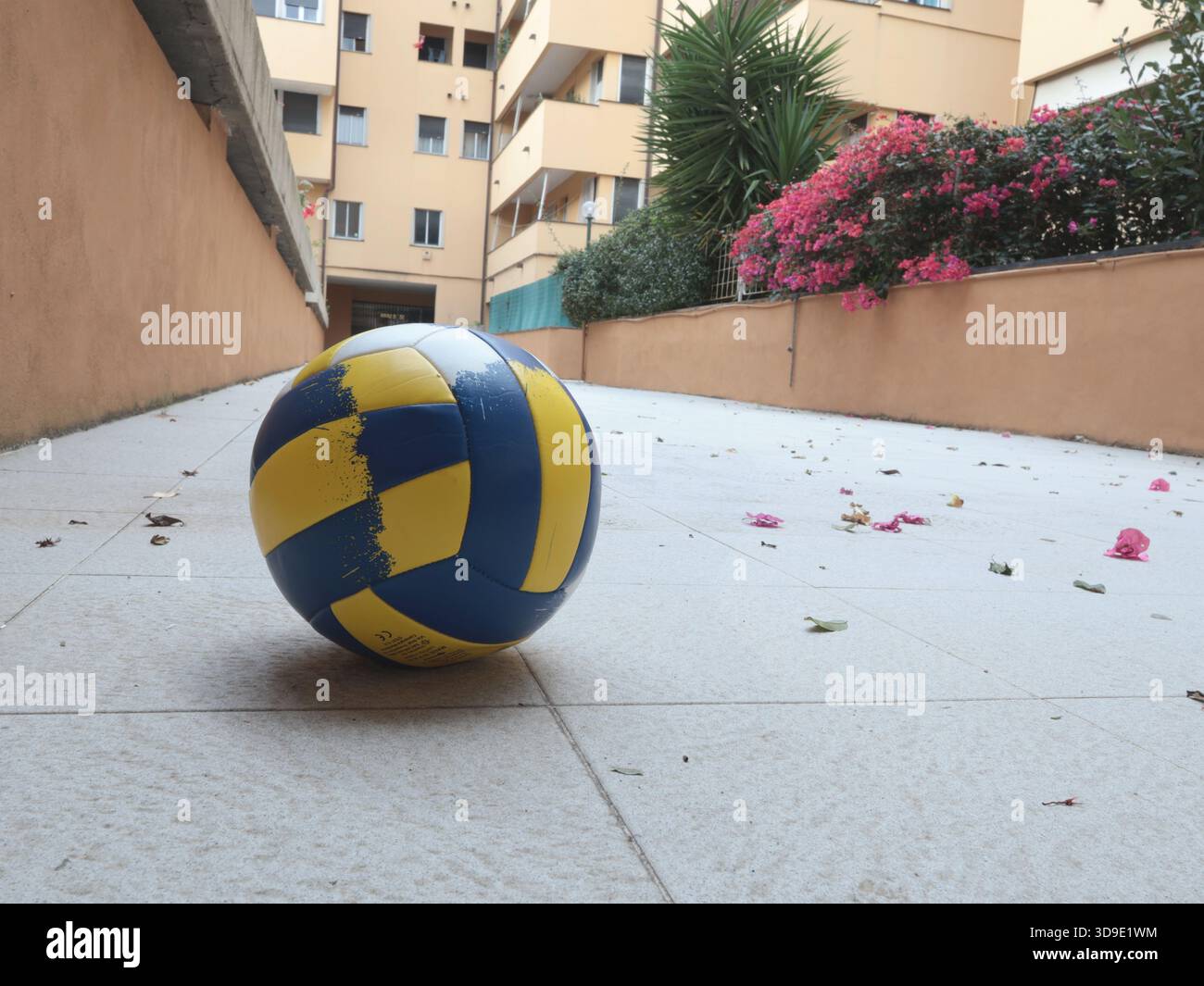 Volleyball in courtyard. Sports and movement. Traditional buildings in Europe, Italy. Design background. Stock Photo