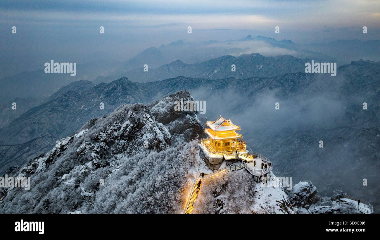 Aerial dawn winter view of the golden Taoist temple on the snowy peak of Laojun Mountain (Laojunshan), Luoyang, Henan Province, China. Stock Photo