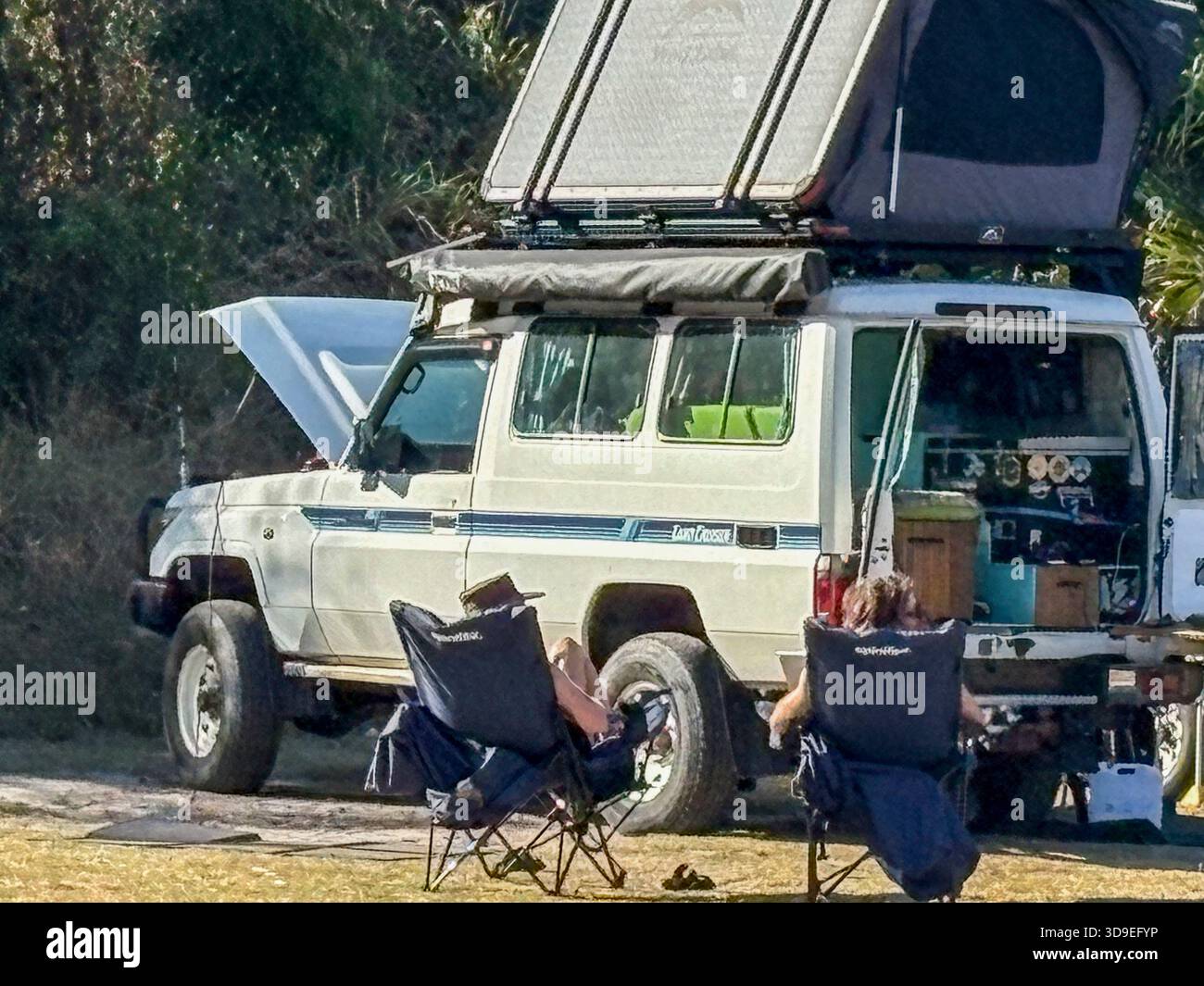 Australia, young couple camping in Myall Lakes national park with off road 4WD Toyota Landcruiser vehicle and rooftop tent installed - Smartphone Captured Stock Image