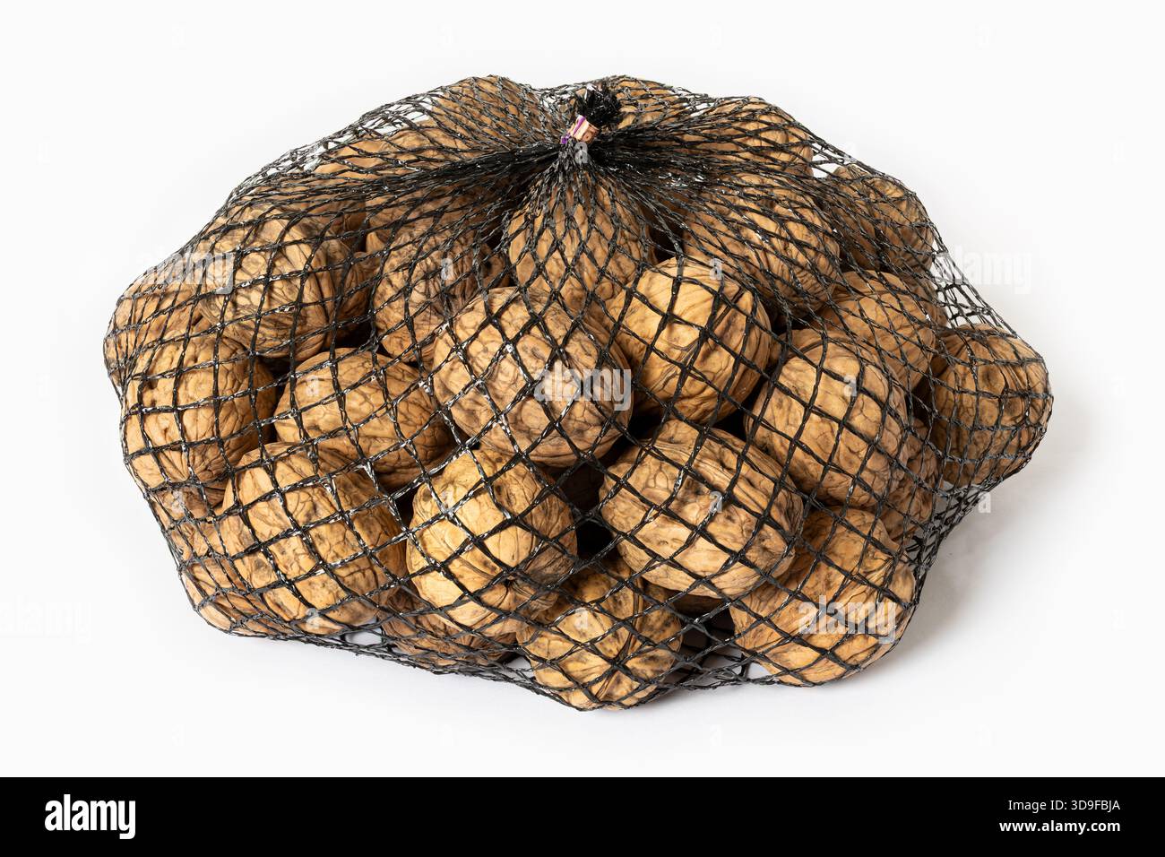 Walnuts in a black mesh bag packaging isolated on white background Stock Photo