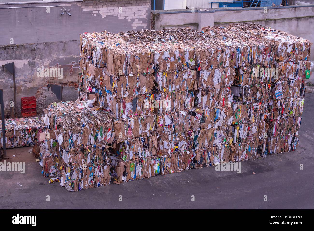 Huge stacks of compressed cardboard bales fill an industrial recycling ...