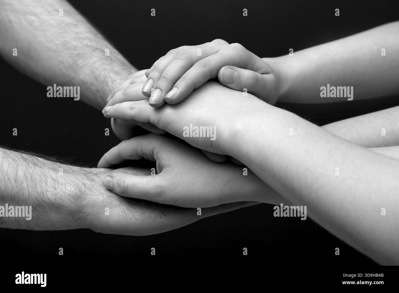 Group of people stacking their hands together, closeup. Black-and-white ...