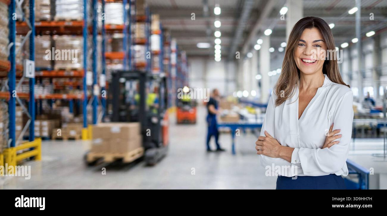 Warehouse manager standing near cardboard boxes background. Stock Photo