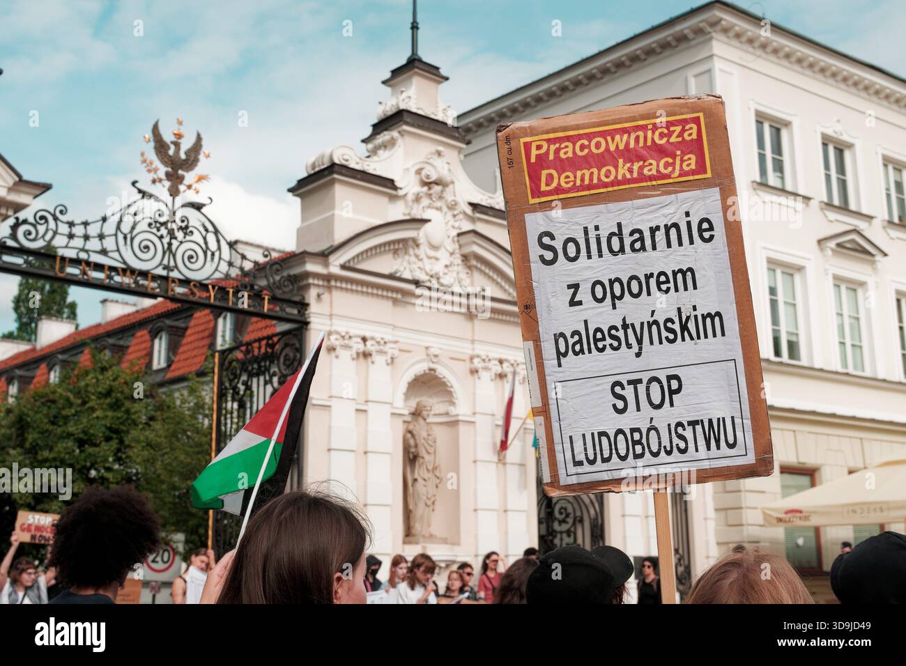Protesters gather near university gates holding signs supporting Palestinian resistance and condemning violence. Stock Photo