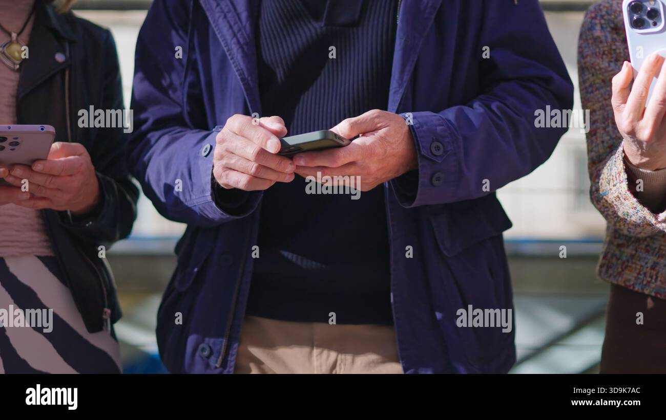 Seniors using their mobile phones outdoors Stock Photo