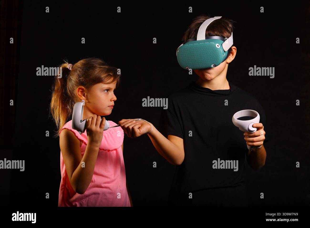 Siblings Interacting with Virtual Reality Headset and Controllers Indoors Stock Photo