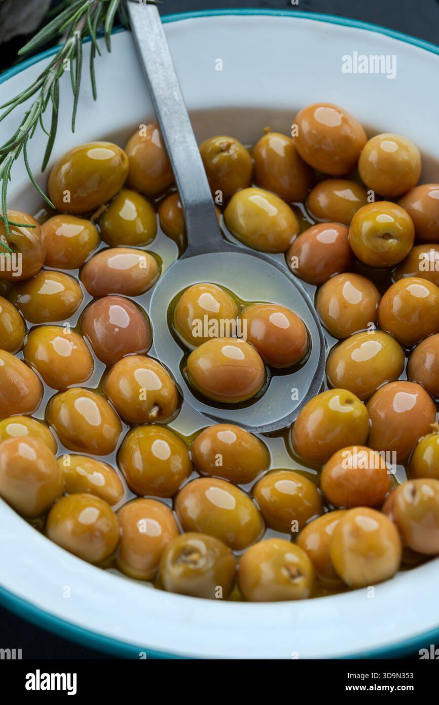 Green Olives in Olive Oil with Spoon and Rosemary Stock Photo - Alamy