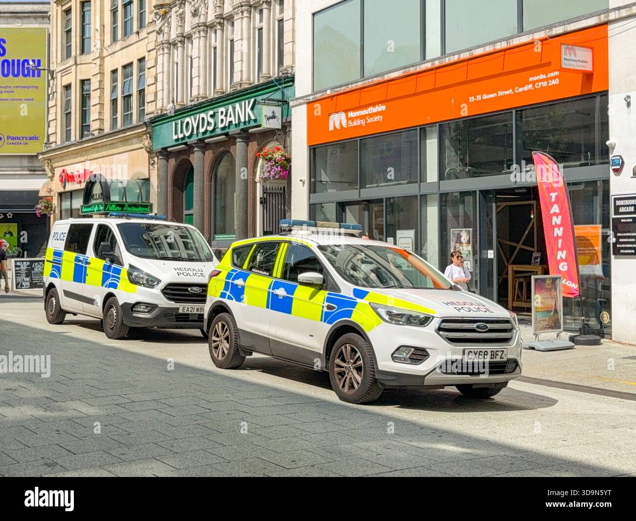 Cardiff, Wales, UK - 15 August 2025: Police car and police van of the South Wales Police force parked in Queen Street, which is a pedestrianised zone - Smartphone Captured Stock Image