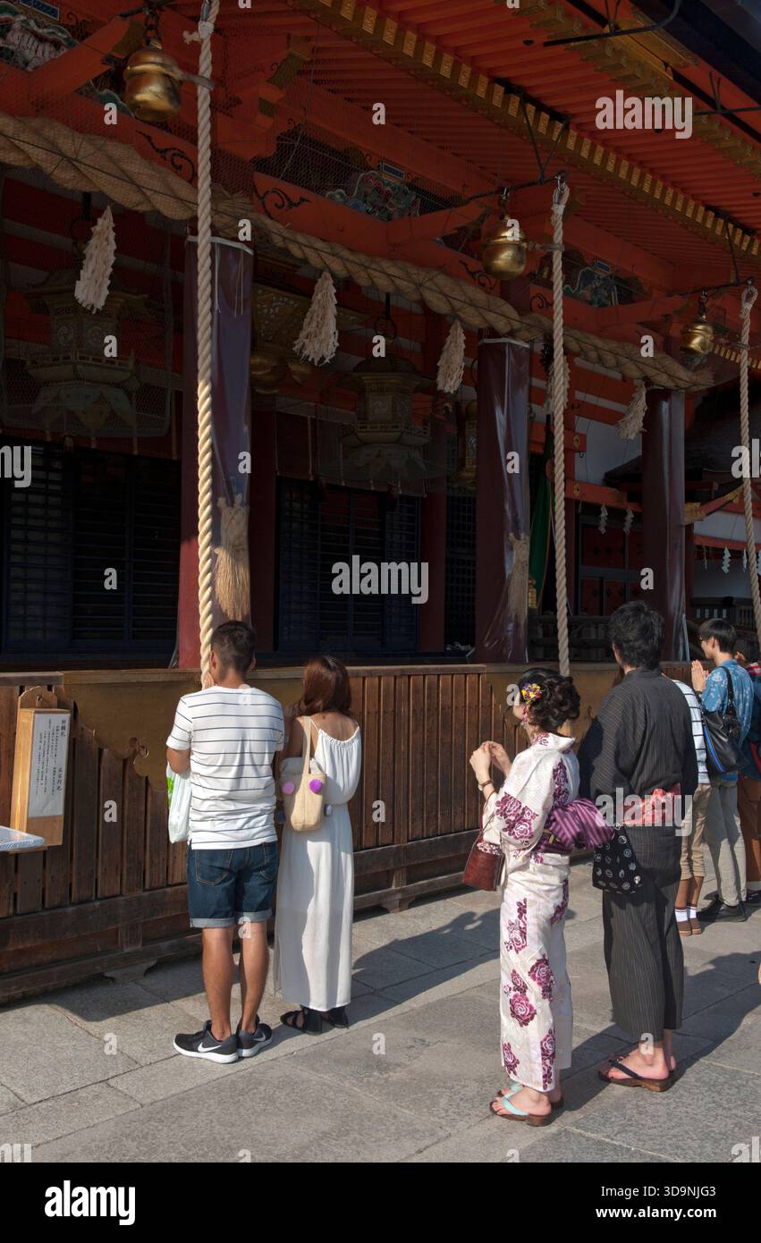 Japanese worshipers praying in front of the hondo (main hall) of Yasaka ...
