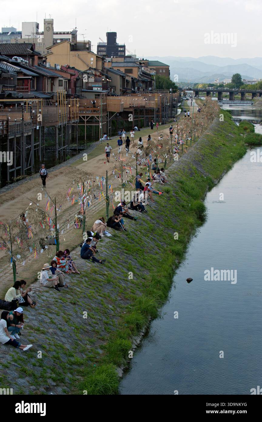 Kamogawa (Kamo River) with Japanese sitting and relaxing on the west ...