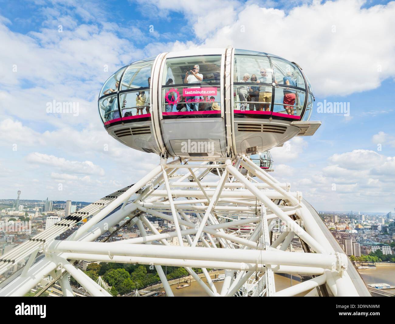 Tourists and visitors looking out of the a passenger capsule of the London Eye at the apex of its ascent into the sky. London, UK. Cantilevered wheel - Smartphone Captured Stock Image