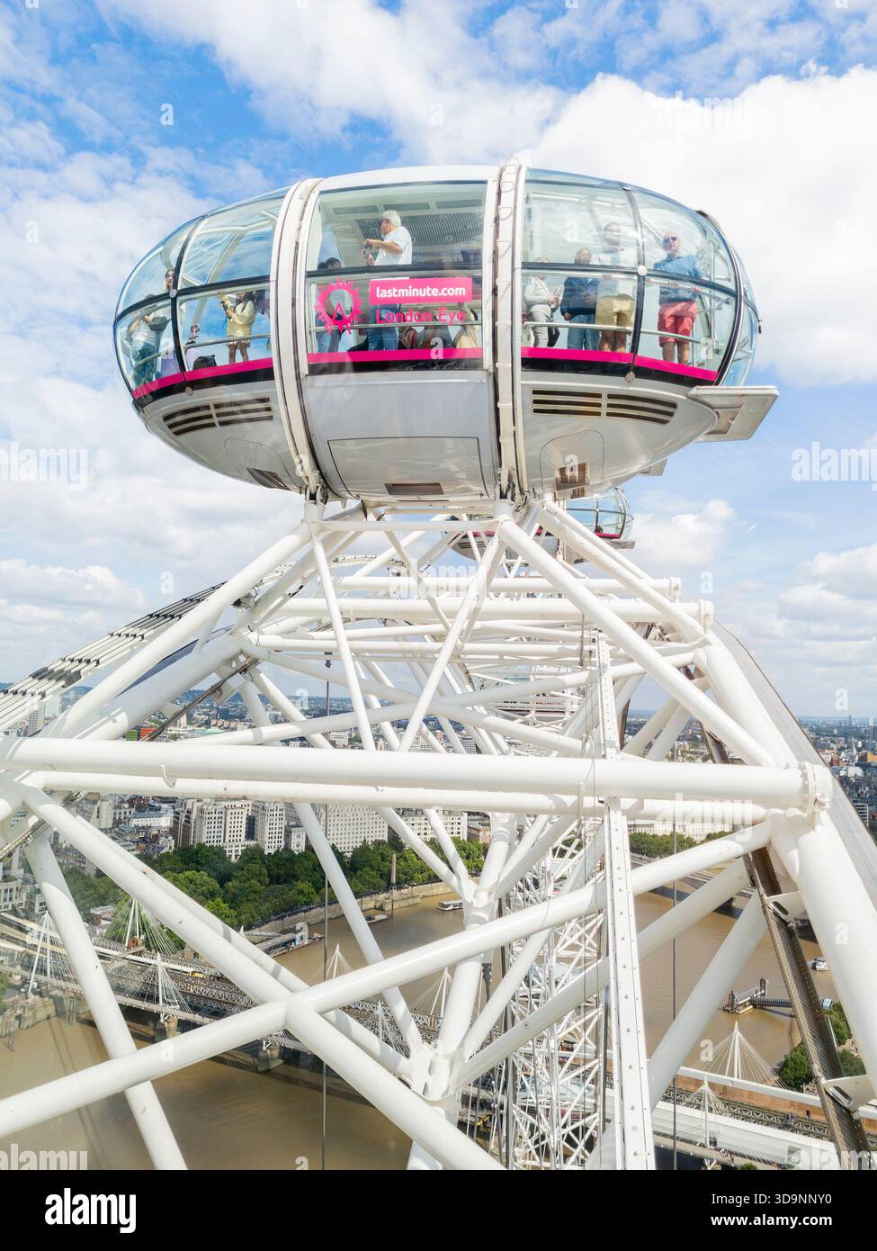 Tourists and visitors looking out of the a passenger capsule of the London Eye at the apex of its ascent into the sky. London, UK. Cantilevered wheel - Smartphone Captured Stock Image