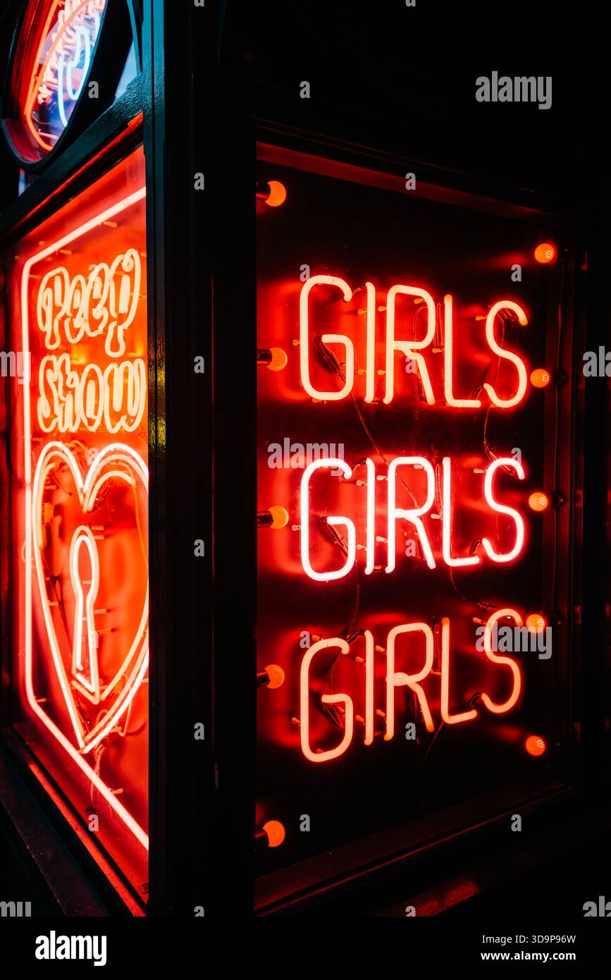 Red neon signs advertising 'Girls Girls Girls' and 'Peep Show', Soho, Westminster, London, England, UK Stock Photo