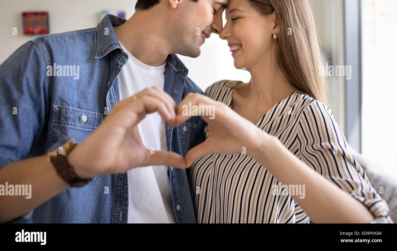 Loving couple making heart shape with hands Stock Photo