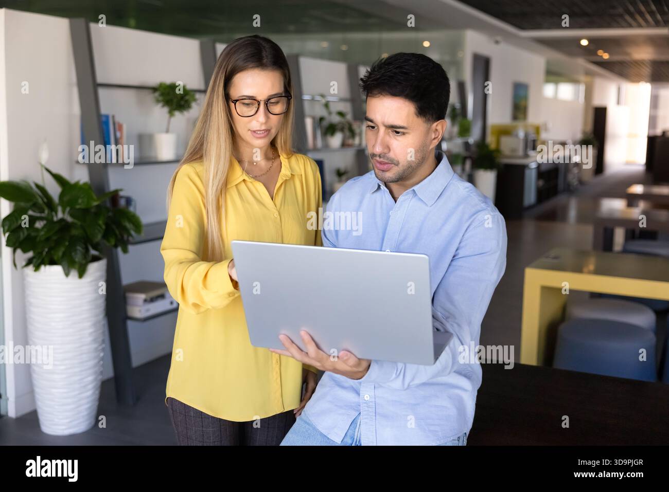 Two focused busy young professionals working on online task together Stock Photo